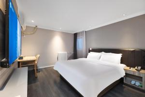 北京Hanting Hotel Beijing West Railway Station South Square的配有一张大床和一张书桌的酒店房间