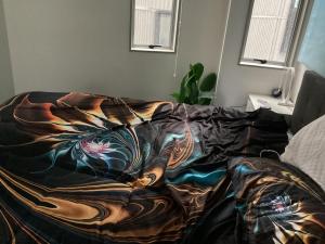 Una cama con una manta encima. en 6 Scotia, en Auckland