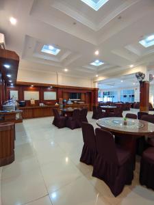 a large lobby with a table and chairs at Hotel Diana in Lhokseumawe