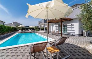 a pool with two chairs and an umbrella and a pool at Gorgeous Home In Debeljak With Wifi in Debeljak