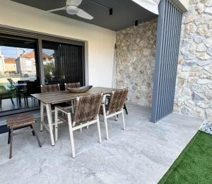 a wooden table and chairs on a patio at Trinity Pool Villas GOLD in Iraklitsa
