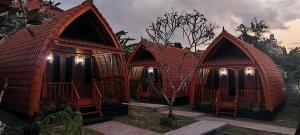 four cottages are lined up in a row at Nusa Dua Huts Pondok Gajah Para in Nusa Dua