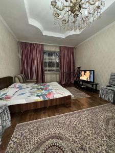 a bedroom with a large bed and a chandelier at Пугачева 17 in Almaty