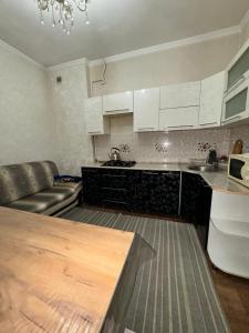 a kitchen with a couch and a table in a room at Пугачева 17 in Almaty