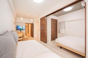 a bedroom with two beds and a dining room at Japan House 御徒町 in Tokyo
