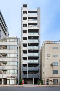 a tall apartment building next to two tall buildings at Japan House 御徒町 in Tokyo