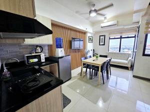 a kitchen and dining room with a stove and a table at Mabolo Garden Flats Loft by Cebu Getaway in Sampong