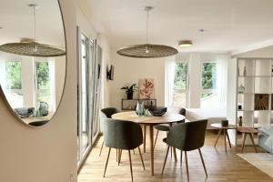 una sala da pranzo con tavolo, sedie e uno specchio di Modernes Studio im Dachgeschoß a Wiener Neustadt Altre 25 foto