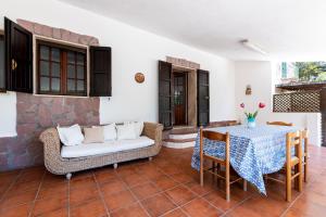 a living room with a table and a couch at Segni Holiday Home in Carloforte