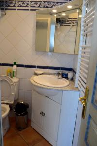 a bathroom with a sink and a toilet and a mirror at Résidence C2M Appartement sur plage Grau du Roi in Le Grau-du-Roi