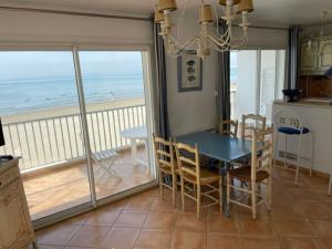 a dining room with a table and a view of the ocean at Résidence C2M Appartement sur plage Grau du Roi in Le Grau-du-Roi +7 photos