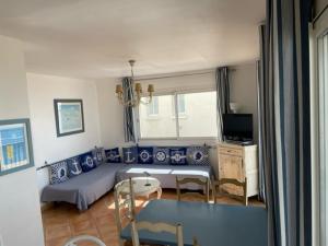 a living room with a couch and a table at Résidence C2M Appartement sur plage Grau du Roi in Le Grau-du-Roi