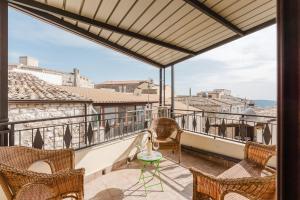 a balcony with chairs and a table and a view of the city at Il Giardino Dei Semplici in Giuliana