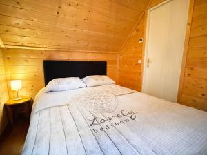 a bedroom with a bed in a wooden cabin at De Schutkooi - Tiny Houses in Vortum-Mullem