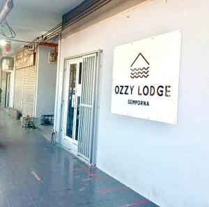 a sign on the side of a building at Ozzy Lodge Semporna in Semporna