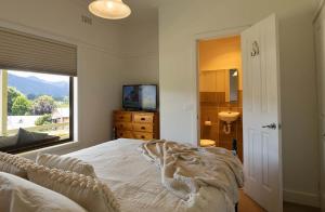 - une chambre avec un lit, une fenêtre et un lavabo dans l'établissement Cosy Candlewick Cottage - A Mount Beauty Delight, à Mount Beauty