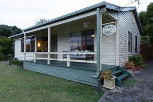 une maison avec une grande terrasse munie d'une table. dans l'établissement Cosy Candlewick Cottage - A Mount Beauty Delight, à Mount Beauty