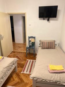 a room with two beds and a flat screen tv at Tri srca 2 - De Luxe 2 in Trebinje +8 photos
