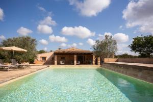 a swimming pool in front of a house at Agroturismo Petit Hotel Son Perdiu - Adults Only in Sa Ràpita