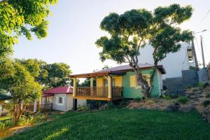 a green and yellow house with a deck at Les Ti Kaz d'Auguste in Les Avirons