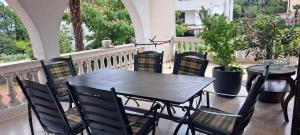 a black table and chairs on a porch at Apartment Nevija e Natale in Opric