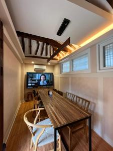 ein Esszimmer mit Tisch und Fernseher in der Unterkunft Seoul Bukchon Homi Hanok in Seoul