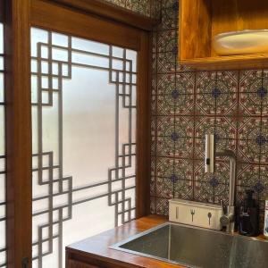 eine Küche mit einem Waschbecken und eine Wand mit einem Fenster in der Unterkunft Seoul Bukchon Homi Hanok in Seoul + 44 Fotos