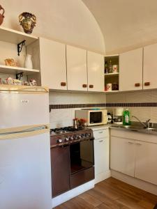 a kitchen with white cabinets and a stainless steel appliance at La Taverna del Ricetto in Candelo