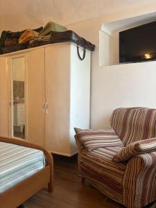 a living room with a couch and a tv on the wall at La Taverna del Ricetto in Candelo