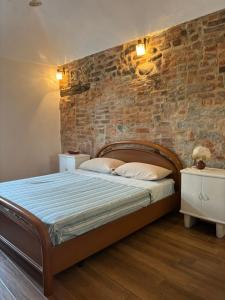 a bedroom with a brick wall and a bed at La Taverna del Ricetto in Candelo