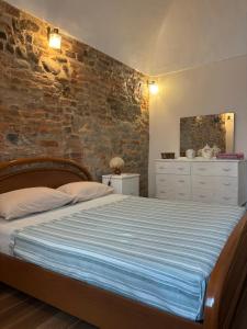 a bedroom with a bed and a brick wall at La Taverna del Ricetto in Candelo