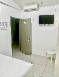 a room with a door and a tv on the wall at Ozzy Lodge Semporna in Semporna