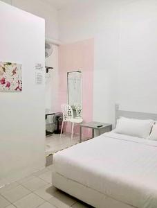 a bedroom with a bed and a table and a mirror at Ozzy Lodge Semporna in Semporna