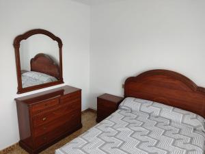 a bedroom with a bed and a dresser and a mirror at CASA Lia galicia in Marín