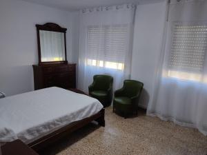 a bedroom with two chairs and a bed and a mirror at CASA Lia galicia in Marín