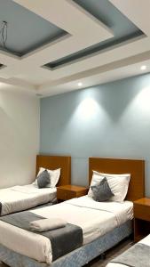 deux lits dans une chambre aux murs bleus dans l'établissement Masa Residences-شقق الماسة, à Médine