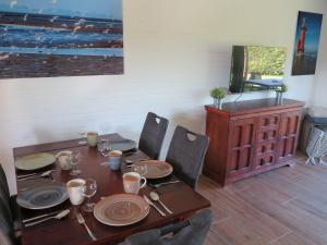 a wooden table with plates and utensils on it at Nordseeferienhaus Emma Tossens in Butjadingen