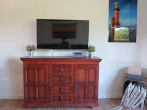 a wooden dresser with a mirror on top of it at Nordseeferienhaus Emma Tossens in Butjadingen +10 photos