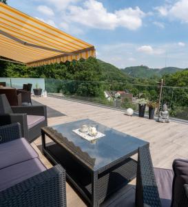 a patio with a table and chairs on a deck at Ferienhaus Burgblick in Hürtgenwald +9 photos