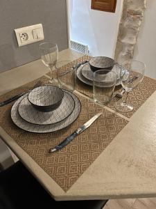a table with plates and wine glasses on it at Studio dans le vieil Antibes in Antibes
