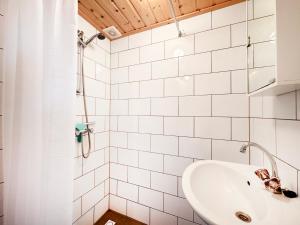 a white bathroom with a sink and a shower at De Schutkooi - Tiny Houses in Vortum-Mullem
