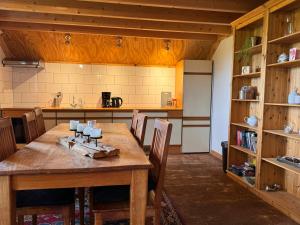 a large kitchen with a wooden table and chairs at De Schutkooi - Tiny Houses in Vortum-Mullem +8 photos