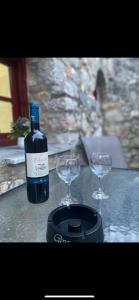 a bottle of wine and two glasses on a table at Mimi's House 1 in Chios