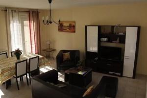 a living room with a couch and a table at St-Quentin la Poterie villa clôturée pour 4 pers avec jardin in Saint-Quentin-la-Poterie
