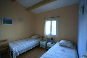 a bedroom with two beds and a window at St-Quentin la Poterie villa clôturée pour 4 pers avec jardin in Saint-Quentin-la-Poterie