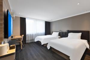 北京Hanting Hotel Beijing West Railway Station South Square的一间有两张床和一台电视的酒店房间