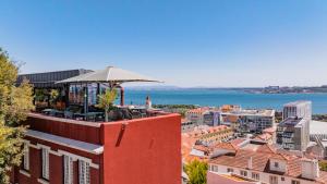 a rooftop cafe with an umbrella on top of a building at Monte Belvedere Hotel by Shiadu in Lisbon