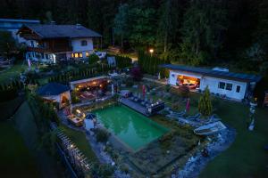 an aerial view of a house with a swimming pool at night at Gästehaus Waldrand Garni in Wiesing