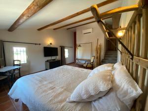 a bedroom with a large white bed and a staircase at Très beau mas provençal entièrement rénové Piscine & SPA entre Dentelles & Ventoux in Violès +39 photos