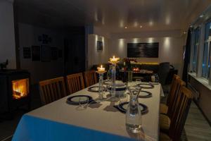 a dining room table with candles on it with a fireplace at Lyngen Flexible Living - Alpine cabins at the start of the mountain in Koppangen